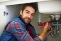 Man, portrait and plumber with wrench for pipe repair, service or fix in home maintenance or indoor leak. Male person or Royalty Free Stock Photo