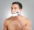 Man, portrait and razor for beard or shaving cream or hair removal foam, grey background or grooming. Asian person, face Royalty Free Stock Photo