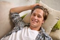Man, portrait and relax on sofa in home or comfortable on weekend for lazy vacation, resting or living room. Male person