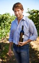 Man, portrait and vineyard with bottle of wine for quality control, agriculture and sustainable winery. Vintage, red Royalty Free Stock Photo