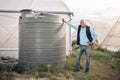 Man, portrait and water tank in farming liquid or soil hydration for vegetables, food and crops growth. Irrigation Royalty Free Stock Photo