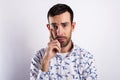 Man portriat over white background, thinking with hand near his