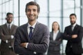 a man poses for the camera with his arms crossed in front of his colleagues Royalty Free Stock Photo