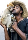 A man poses for a photograph with his monkey in Djemaa el-Fna, the main square in the Marrakesh medina in Morocco. Royalty Free Stock Photo