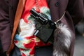 Man poses for photographers with gun bag with fur tail before Etro and Iceberg fashion show, Milan Fashion