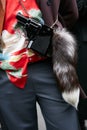 Man poses for photographers with gun bag with fur tail before Etro and Iceberg fashion show, Milan Fashion