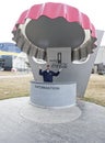 A man poses by a piece of art that resembles a bottle cap outside of the World of Coke Royalty Free Stock Photo