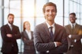 a man poses for the camera with his arms crossed in front of his colleagues Royalty Free Stock Photo