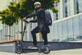 A man posing on electric scooter.