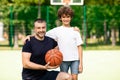 Man posing with little boy on basketball pitch Royalty Free Stock Photo