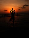 Man Posing in Vriksha Asana Yoga Pose on the sea beach during sunrise