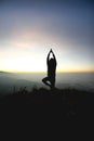 Man posing yoga on top of misty mountain cliff Royalty Free Stock Photo