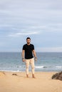 Man posing barefoot on the beach wearing casual a black t-shirt Royalty Free Stock Photo