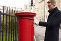 Man Posting Letter In Red British Postbox Royalty Free Stock Photo