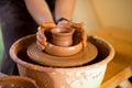 Man potter work with clay ware. Young man potter on his workshop with nature background