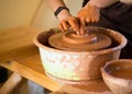 Man potter work with clay ware. Young man potter on his workshop with nature background