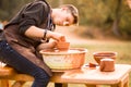 Man potter work with clay ware. Young man potter on his workshop with nature background Royalty Free Stock Photo