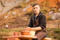 Man potter work with clay ware. Young man potter on his workshop with nature background