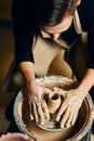 Man potter working on potters wheel making ceramic pot from clay in pottery workshop Royalty Free Stock Photo