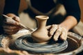 Man potter working on potters wheel making ceramic pot from clay in pottery workshop Royalty Free Stock Photo