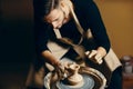 Man potter working on potters wheel making ceramic pot from clay in pottery workshop Royalty Free Stock Photo