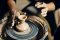 Man potter working on potters wheel making ceramic pot from clay in pottery workshop Royalty Free Stock Photo