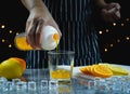 man pour orange juice in glass near slice fresh lemon and orange Royalty Free Stock Photo