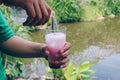 A man pour a soda into a glass of milk and red syrup to make pink milky soda or Soda Gembira