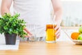 Man pouring apple juice from jug into an empty glass in the kitchen