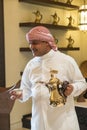 Man pouring Arabic coffee from a traditional Arabic Dallah coffee pot