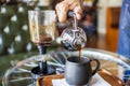Man pouring coffee from syphon or vacuum tube coffee maker with blur background.Vintage siphon system machine. Royalty Free Stock Photo