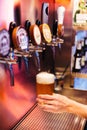 Man pouring craft beer from beer taps in frozen glass with froth. Selective focus. Alcohol concept. Vintage style. Beer craft. Royalty Free Stock Photo