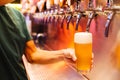 Man pouring craft beer from beer taps in frozen glass with froth. Selective focus. Alcohol concept. Vintage style. Beer craft Royalty Free Stock Photo