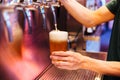 Man pouring craft beer from beer taps in frozen glass with froth. Selective focus. Alcohol concept. Vintage style. Beer craft. Royalty Free Stock Photo