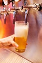 Man pouring craft beer from beer taps in frozen glass with froth. Selective focus. Alcohol concept. Vintage style. Beer craft. Royalty Free Stock Photo
