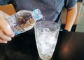 Man Pouring Drinking Water into a Glass of Iced Cubes Royalty Free Stock Photo