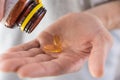 Man pouring fish oil capsules with omega 3, vitamin D in hand from medicine bottle. Nutritional supplement. Health Royalty Free Stock Photo