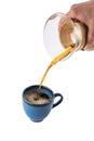 Man is pouring hot coffee from the coffee pot into blue cup isolated on white background Royalty Free Stock Photo