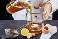 Man pouring kombucha SCOBY tea into jar