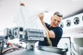 Man pouring malt to brewery equipment for craft beer production.