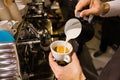 Man Pouring Milk into Coffee Making Espresso. Royalty Free Stock Photo