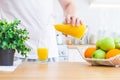 Man pouring orange juice from jug into glass in the kitchen Royalty Free Stock Photo