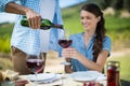 Man pouring red wine in glass held by woman Royalty Free Stock Photo