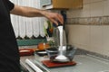 Man pouring sugar in a glass bowl that's on the weighing scale in the kitchen