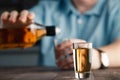 Man is pouring tequila into glass