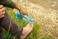 Man pouring water in feet from bottl