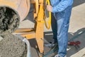 Man pouring wet cement into wheelbarrow from mixer Royalty Free Stock Photo