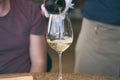 Man pouring wine into glass in a restaurant. Waiter serving drink. Wine tasting concepts