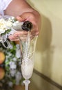 Pours champagne in the into an elegant glass. Wedding celebration