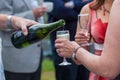 Man pours champagne in wineglasses of a woman dressed in red Royalty Free Stock Photo